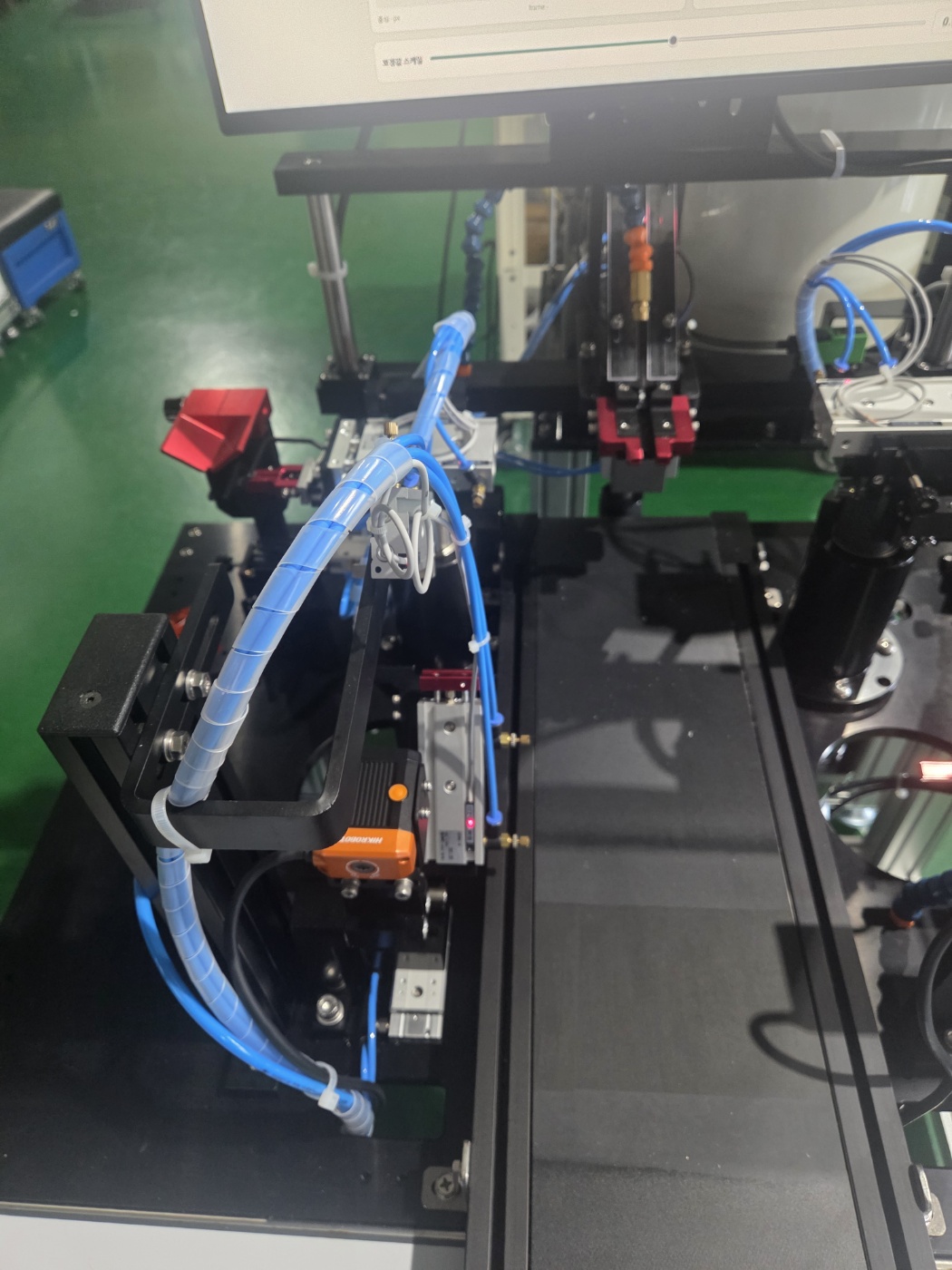 Detalhe real das pinças e linhas pneumáticas azuis da máquina de enxertia