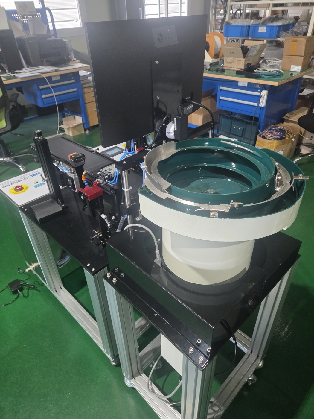 Alimentador circular verde montado na estrutura da máquina de enxertia
